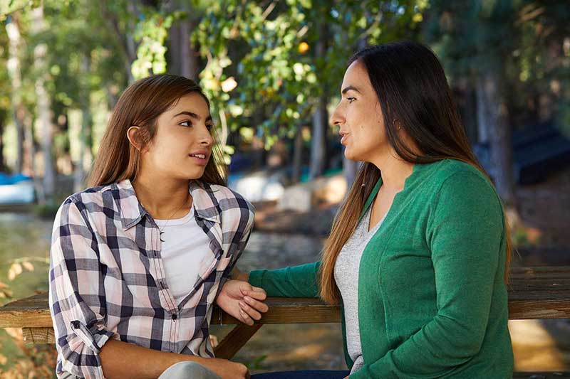 mom and daughter having a conversation outside